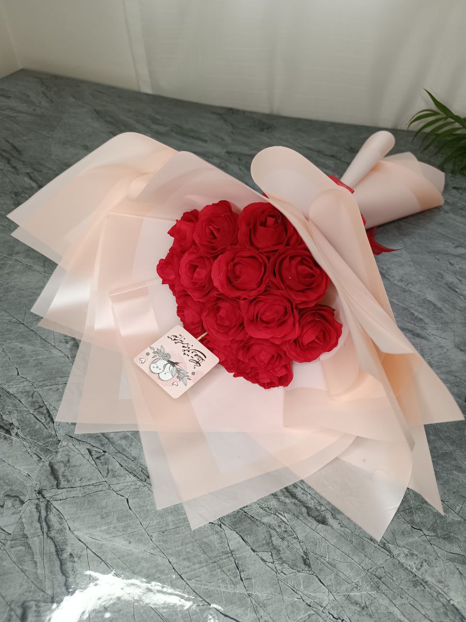 دسته گل مصنوعی رز قرمز با کاغذ گلبهی (۱۵شاخه)