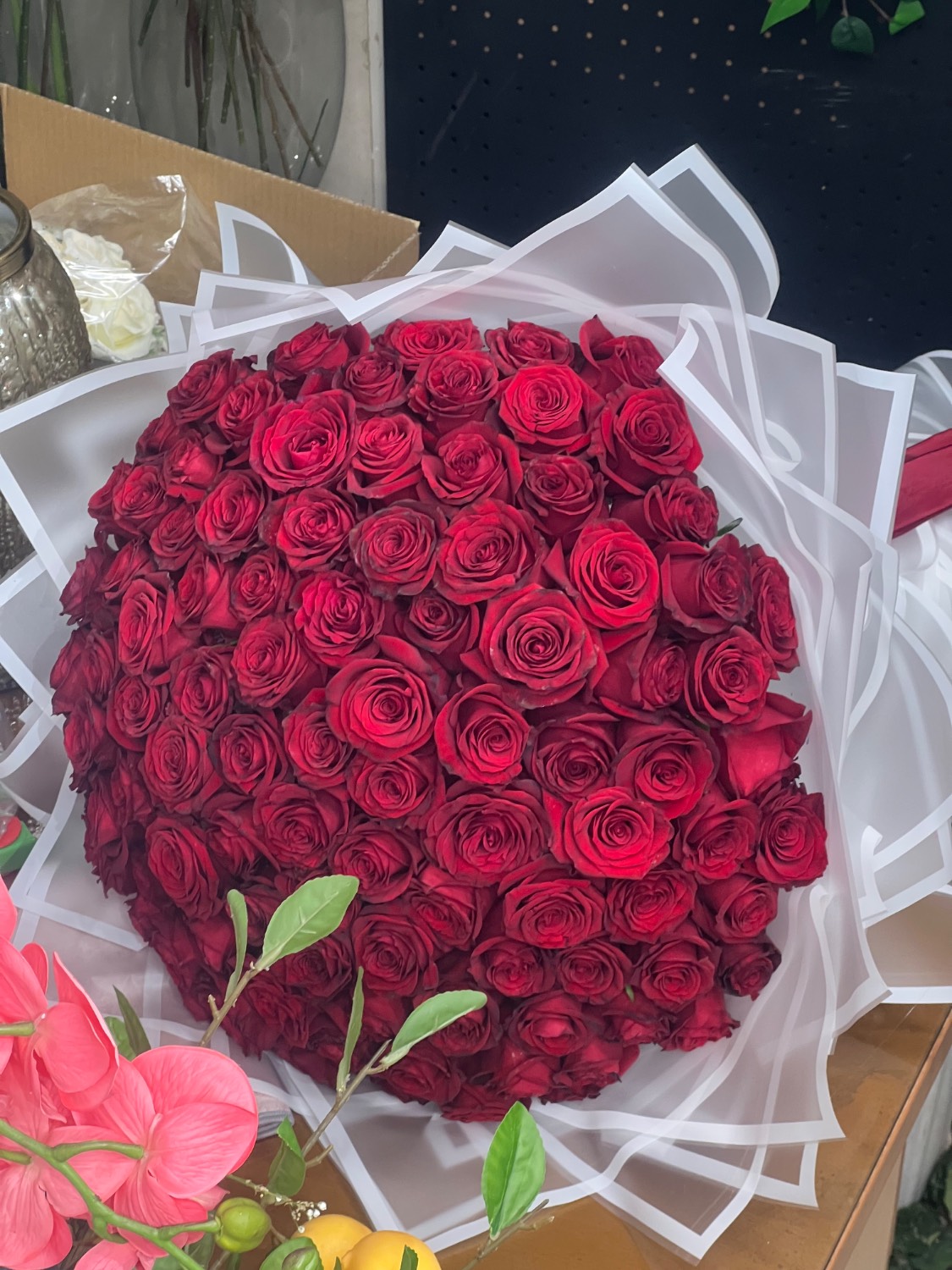 دسته گل رز هلندی ۱۰۰شاخه قرمز با کاغذ سفید